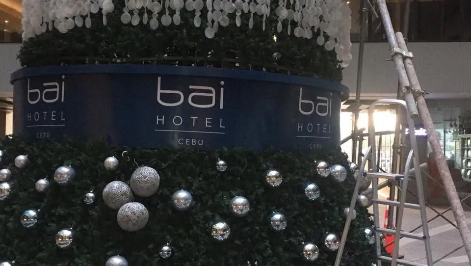 MCAV crew installing a Bai Hotel Cebu tarpaulin at Bai Hotel Cebu