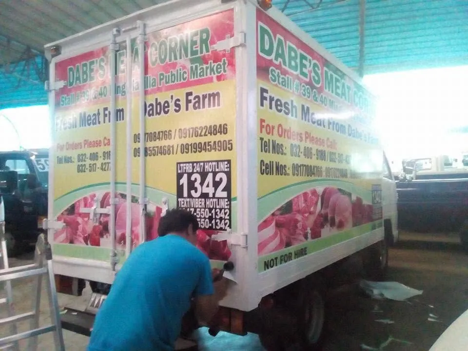 MCAV crew installing a Dabe's Meat Corner vehicle wrap