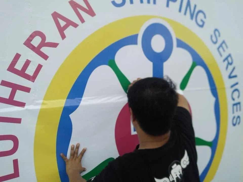 MCAV crew installing a Lutheran Shipping Services vinyl graphics