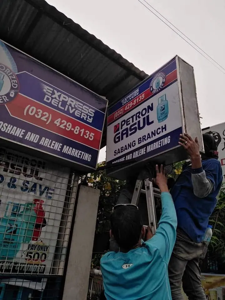 MCAV crew installing a Petron Panaflex sign