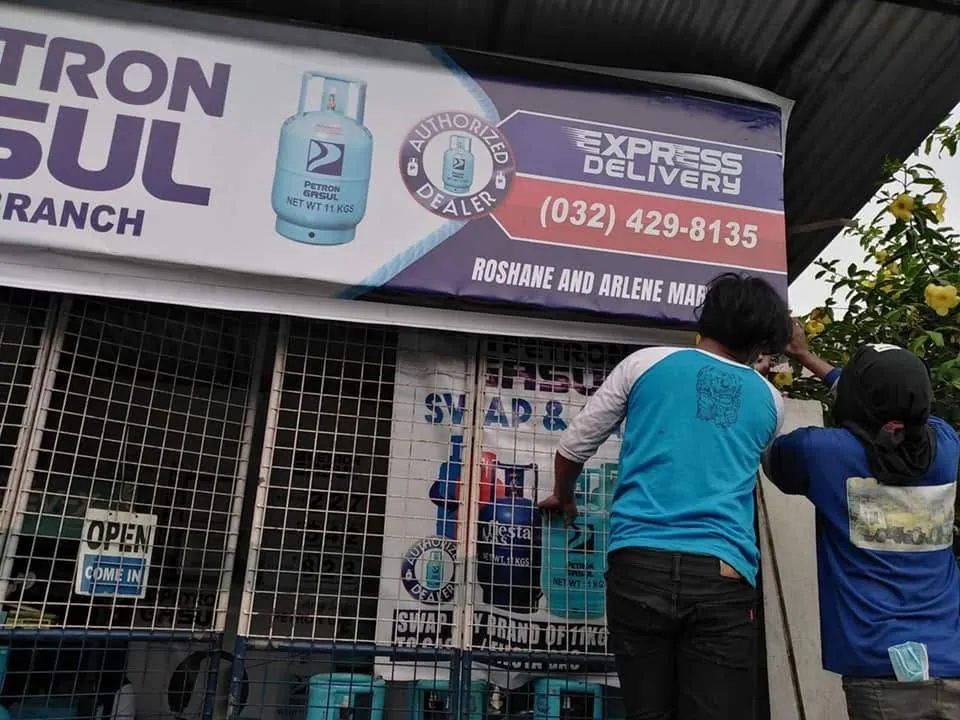 MCAV crew installing a Petron Panaflex sign
