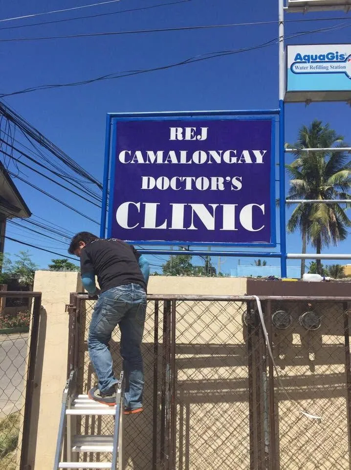 MCAV crew installing a REJ Camalongay Doctor's Clinic sign