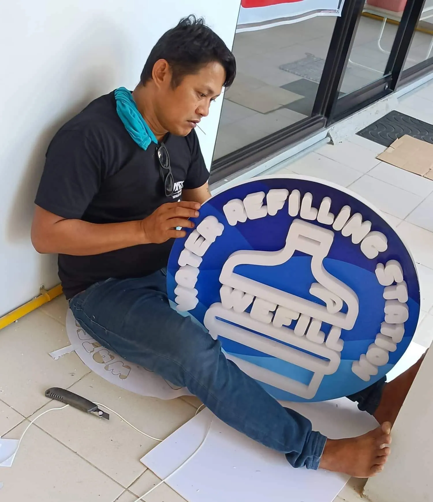 MCAV crew installing a Wefill Water Refilling Station lighted sign